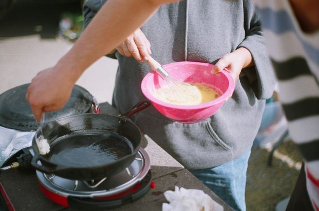 Duas pessoas cozinhando juntas numa cozinha doméstica