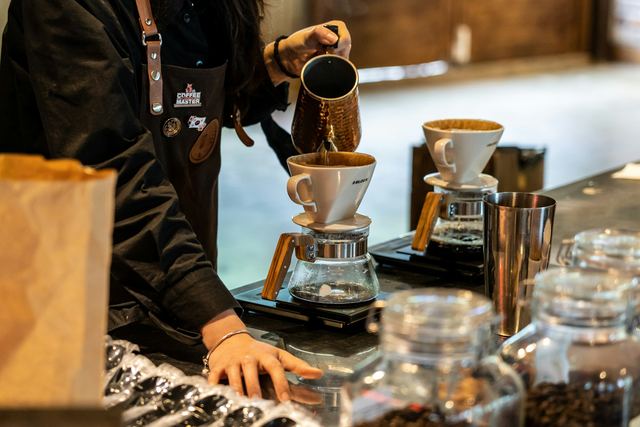 Pessoa despejando café quente numa xícara, com o fio de água caindo do bule