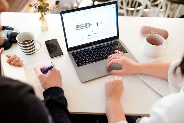 Um homem e uma mulher trabalhando juntos num notebook sobre uma estratégia de marketing