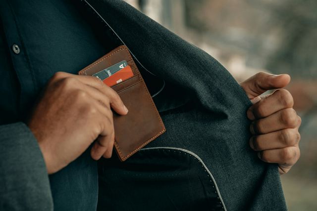 Homem com a mão no bolso segurando uma carteira