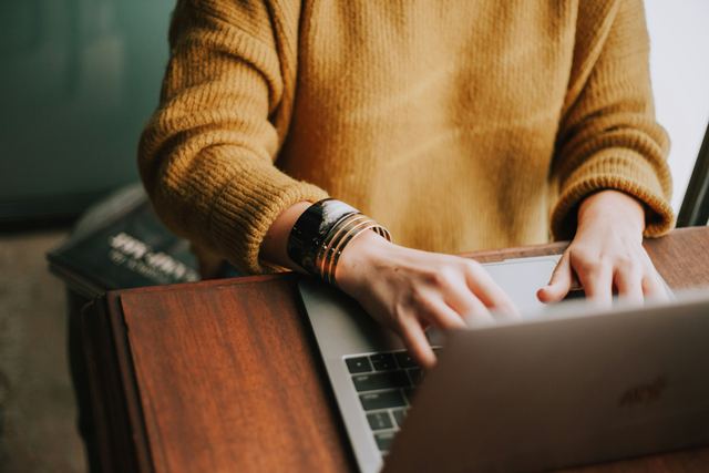 Pessoa trabalhando concentrada num notebook, fazendo contas do preço de um serviço