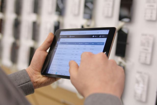 Atendente de loja conferindo itens numa tablet no balcão