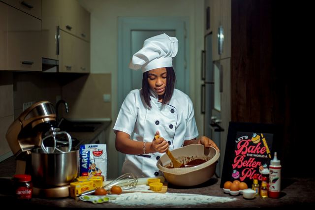 Mulher de uniforme de cozinheira preparando comida numa cozinha
