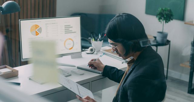 Homem sentado à mesa diante de um computador, escrevendo e calculando quanto vale hoje um dinheiro do futuro