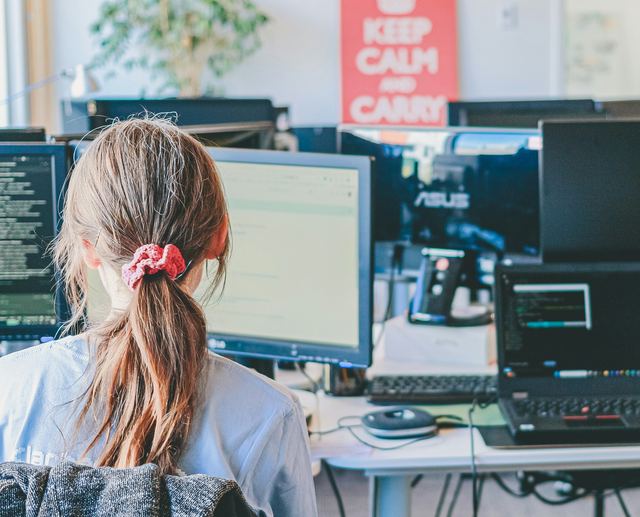 Mulher trabalhando em vários monitores em um escritório