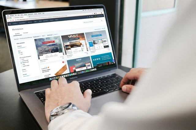 Pessoa trabalhando em um MacBook Pro em uma mesa de escritório