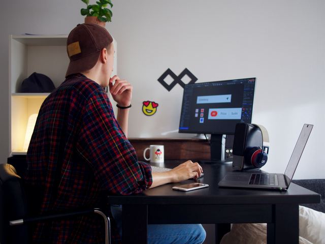 Designer sentado à mesa usando o computador em um escritório minimalista