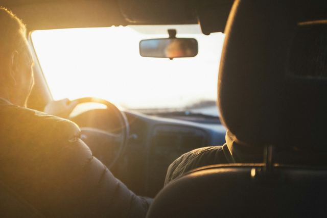Homem ao volante de um carro na luz dourada do fim de tarde